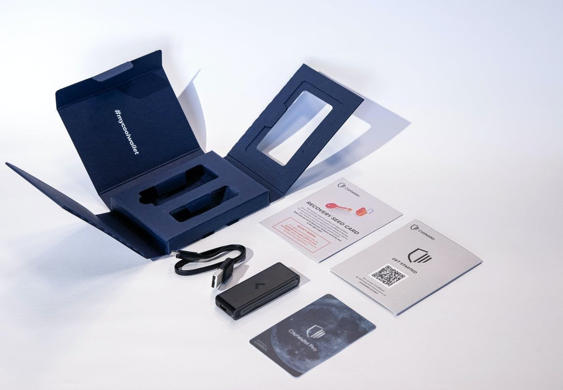 Open CoolWallet Pro box on a desk, with the hardware wallet and other included items neatly displayed outside the box.