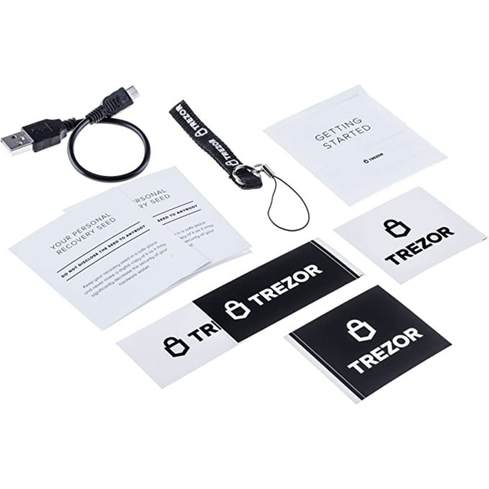 Unboxed Trezor Model One hardware wallet shown alongside its accompanying contents from the package.